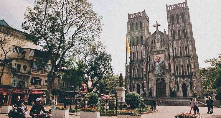 Dom mit Menschen und Motorrädern auf einem Platz.