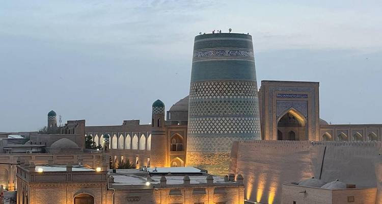 View of historic city with tall architectural towers and evening lighting.