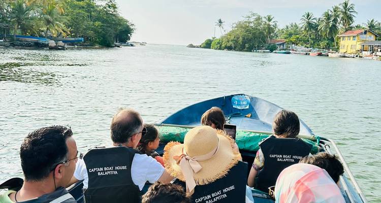 Des touristes lors d'une promenade en bateau dans une voie navigable pittoresque.