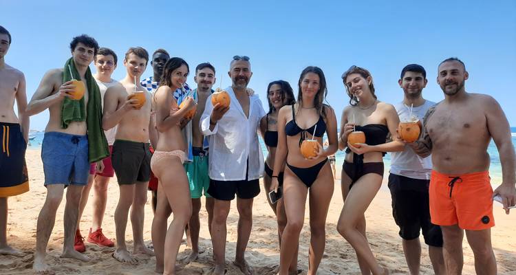 Des gens sur une plage savourant des noix de coco ensemble.