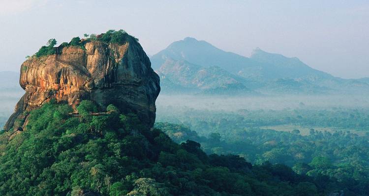 Vue dramatique du rocher de Sigiriya dans un environnement brumeux.