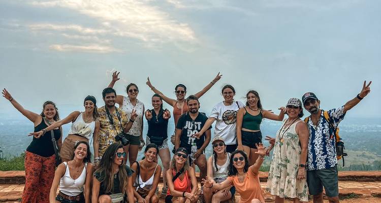 Groupe de personnes enthousiastes posant sur un point de vue.
