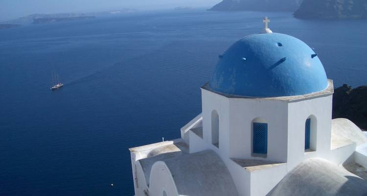 Traditional white and blue church dome overlooking the sea.
