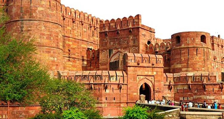 Agra Fort mit seinen roten Sandsteinmauern und dem von Besuchern umgebenen Eingang.