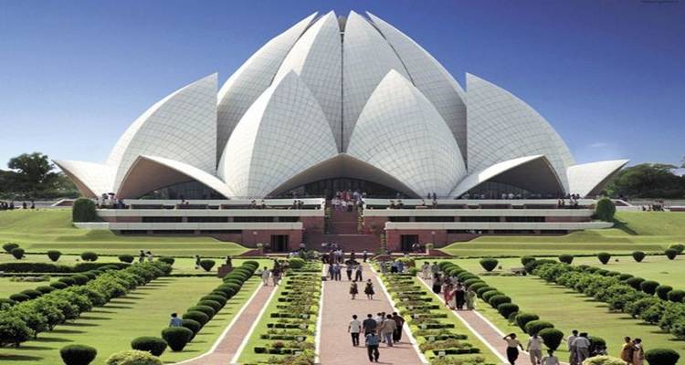 Lotus-shaped temple with green lawns and pathways leading to it.