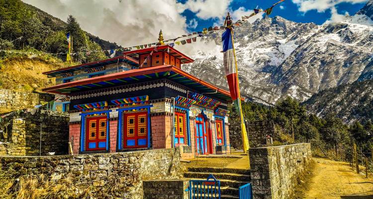 Kleurrijke tempel met bergen op de achtergrond.
