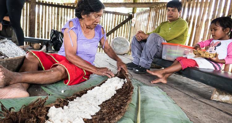 Gruppe von Menschen, die sich mit traditioneller Textilherstellung beschäftigt.
