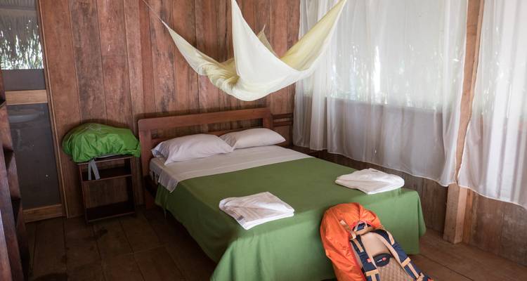 Einfache Unterkunftsausstattung mit Bett und Moskitonetz.