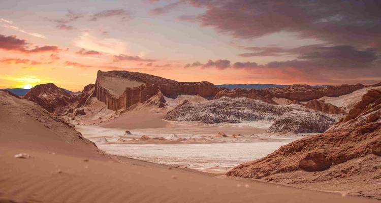 El colorido atardecer ilumina las formaciones rocosas surrealistas y los salares del Valle de la Luna.
