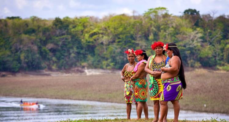 Grupo de personas con vestimenta tradicional cerca de un río.