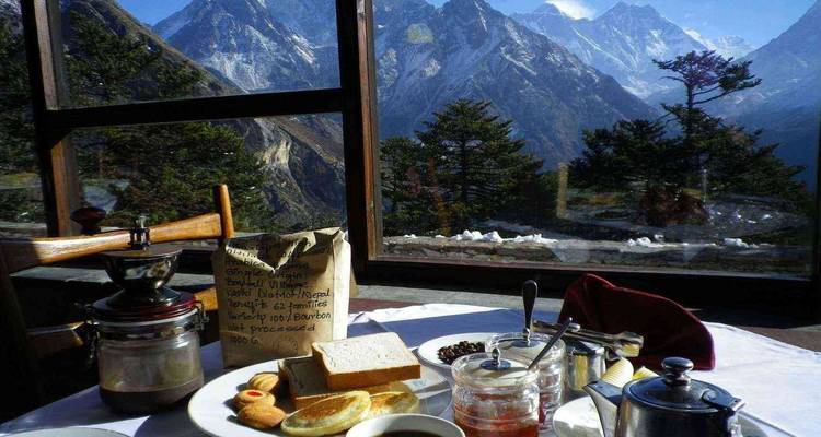 Tafel met ontbijt geserveerd met uitzicht op bergtoppen.