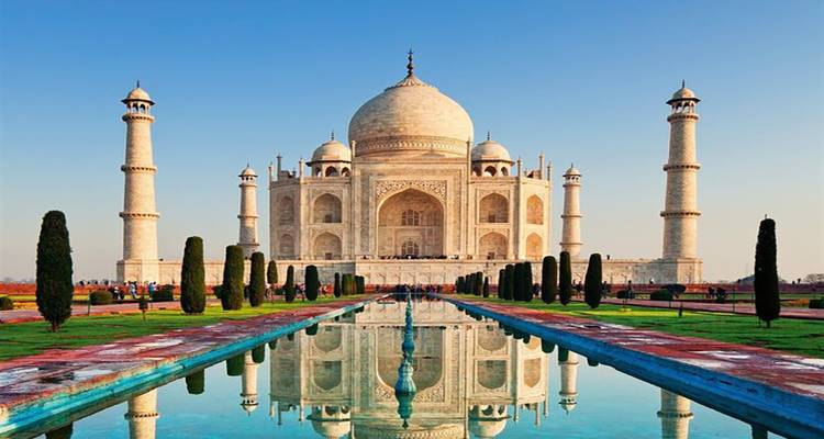 Taj Mahal mit Spiegelung im Wasser im Vordergrund.