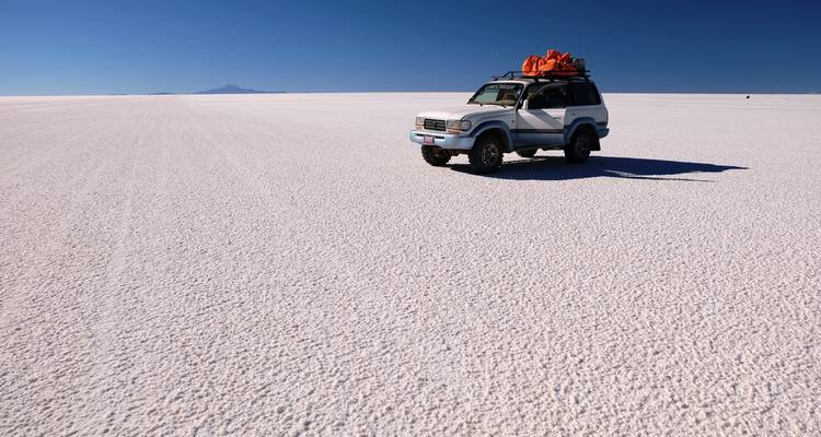4x4 voertuig op de uitgestrekte zoutvlaktes onder een heldere hemel