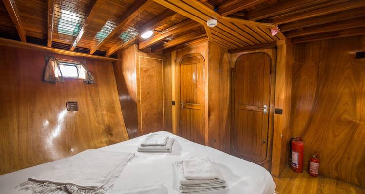 Interior view of a cabin with wooden walls and bed.
