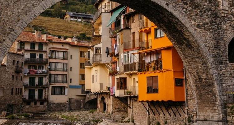 Colorful buildings seen through a stone arch.