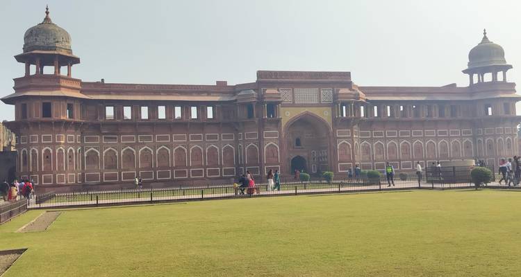 Vista amplia de la imponente puerta de entrada del Fuerte de Agra y el césped bien cuidado del frente bajo una luz brumosa