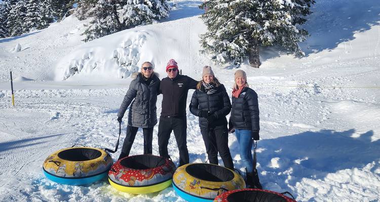 Groupe de personnes profitant de la glissade sur bouée dans un paysage hivernal.