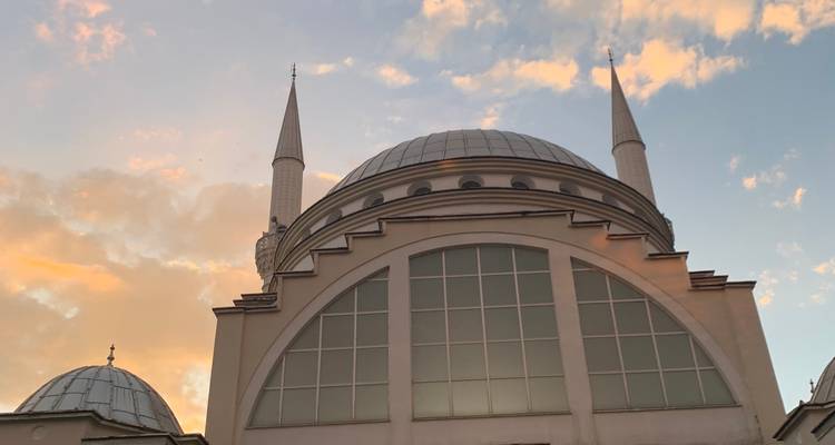 Bâtiment architectural avec dômes et verre réfléchissant.