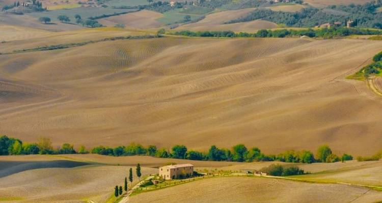 Panoramic view of a farmhouse surrounded by rolling hills.