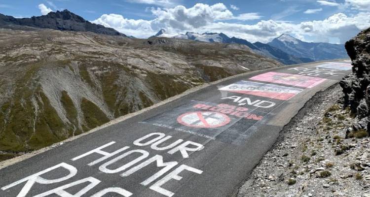 Road with painted messages in a hilly terrain.