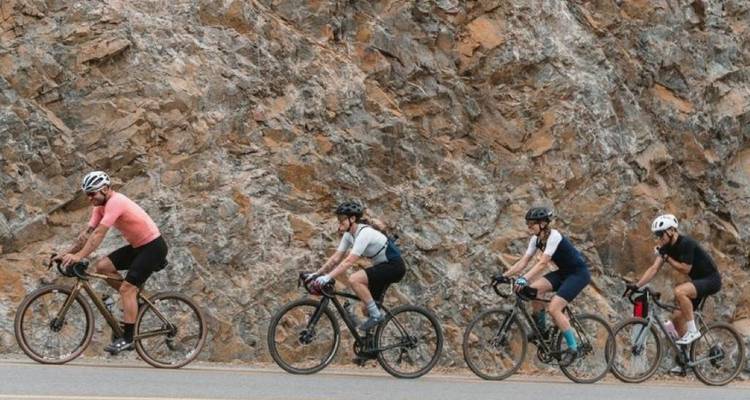 Group of cyclists riding along a rocky road.
