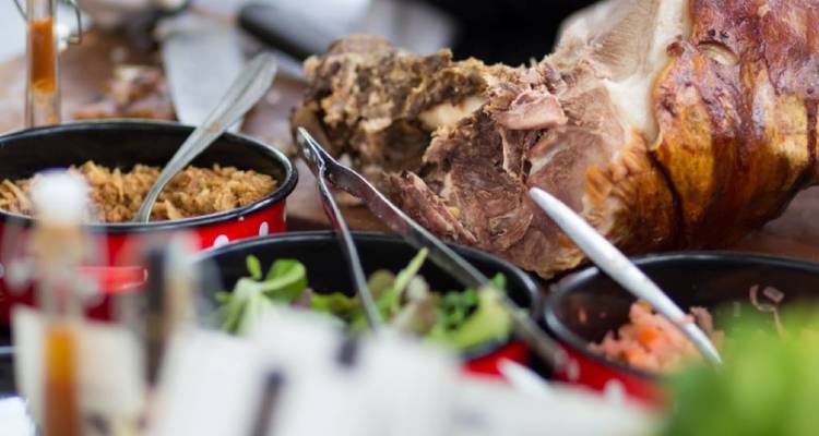 Platter of food with meat, vegetables, and sauces.