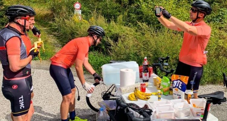 Group of cyclists having a break with snacks and drinks.