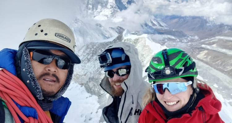 Groep klimmers die een selfie nemen op een besneeuwde berg.