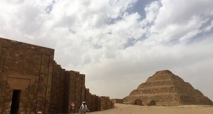 Pyramide à degrés de Djéser avec des gens qui marchent à proximité.