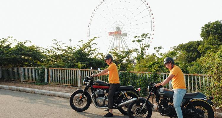Twee mensen op motorfietsen voor een groot reuzenrad.