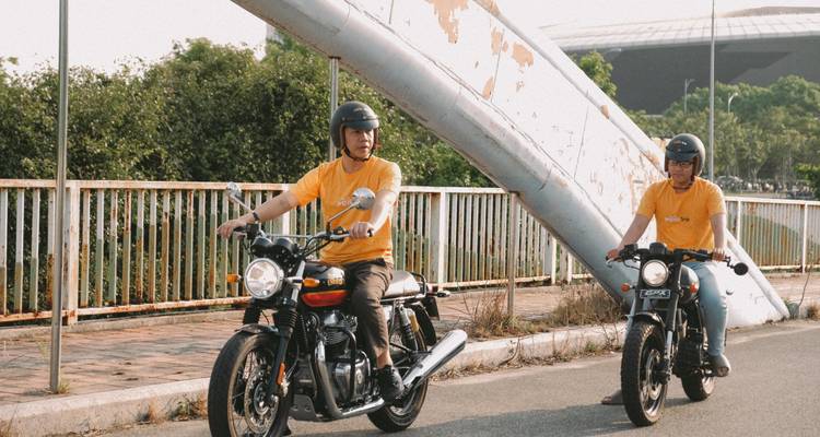 Motorrijders op een weg die een metalen constructie passeren.