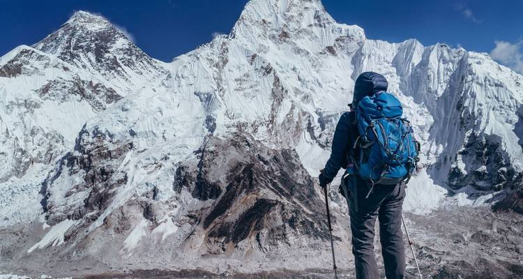 Wanderer blickt auf den Mount Everest bei klarem Himmel.