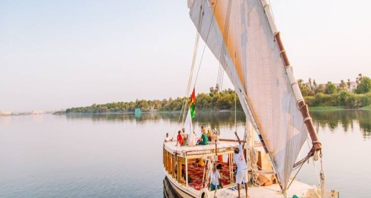 Voilier avec des personnes sur une rivière calme