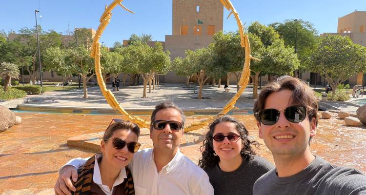 Vier mensen die poseren voor een fotolijst sculptuur.