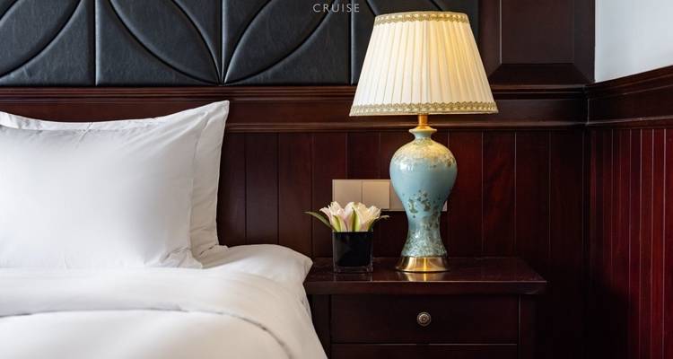 Close-up van een bedlampje naast een bed op een cruiseschip.