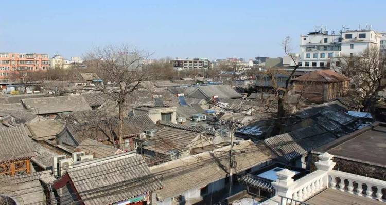 Rooftop view over traditional Chinese buildings in a city.