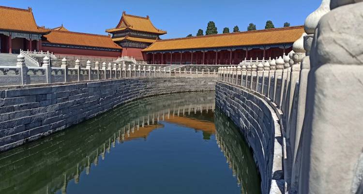 Ancient stone waterway with traditional Chinese buildings and reflections.
