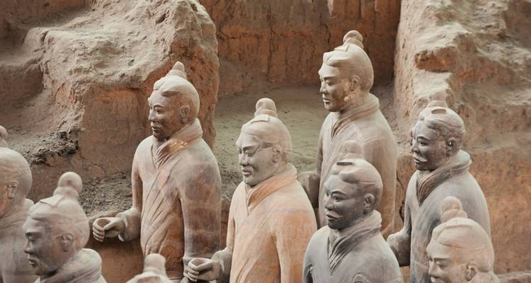 Terracotta warriors standing in rows at an excavation site.