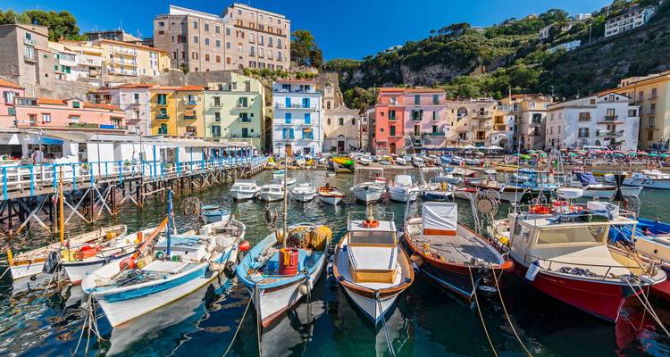 Des bateaux colorés dans une ville côtière animée.