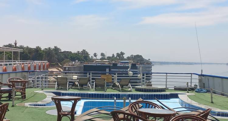 Pont-solarium ouvert d'un bateau de croisière sur le Nil équipé d'une petite piscine, de chaises longues et offrant une vue sur le fleuve.