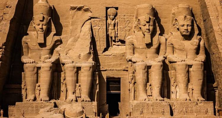 Façade ensoleillée du temple d'Abu Simbel avec quatre gigantesques statues assises.