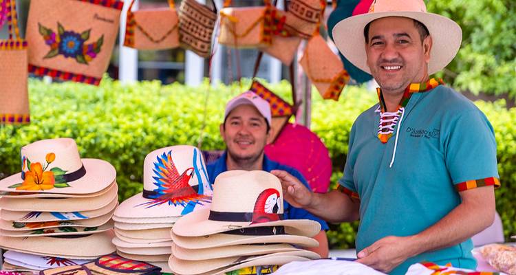 Marché local avec des vendeurs qui vendent des chapeaux et de l'artisanat.