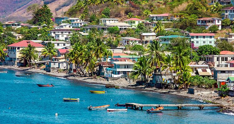 Vue côtière avec des maisons sur une colline près du rivage.