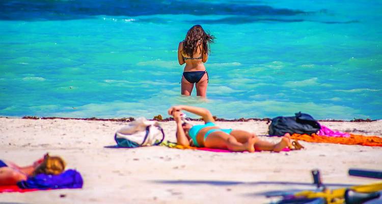 Des gens profitant d'une journée ensoleillée à la plage en maillot de bain.