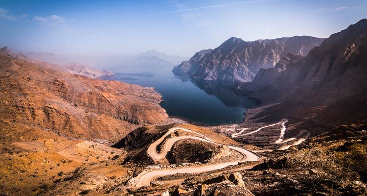 Route de montagne avec vue panoramique sur un plan d'eau.