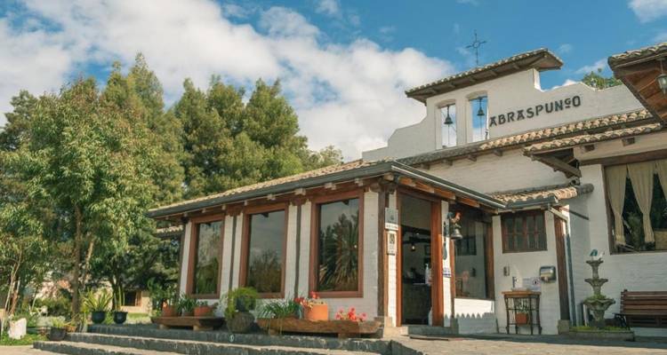 Extérieur de restaurant avec des accents de bois saisissants et une végétation luxuriante.