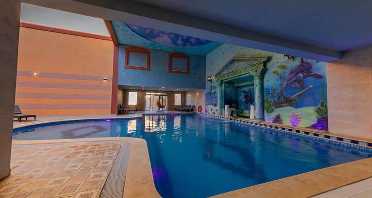 Binnenzwembad met artistieke muurschilderingen.