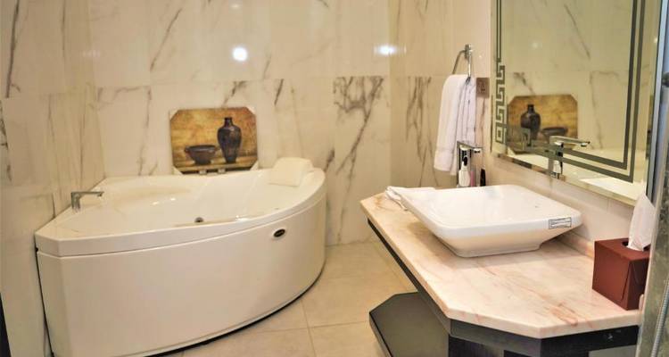 Luxueuze badkamer met een groot bad en marmeren decoratie.