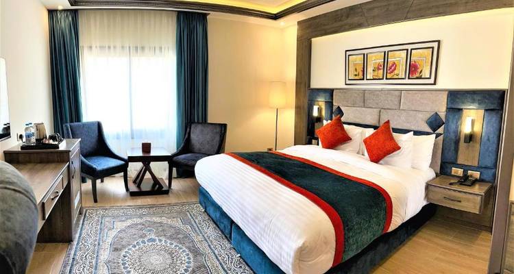 Stijlvolle hotelkamer met levendige inrichting en twee stoelen.