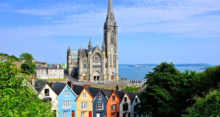 Maisons colorées et une église avec la mer en arrière-plan.